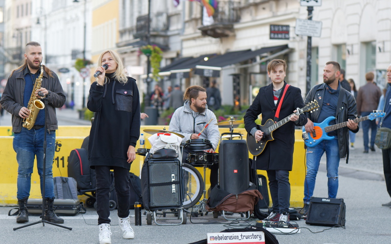 16 - Band performing on a street, identified as a street music performance - 1